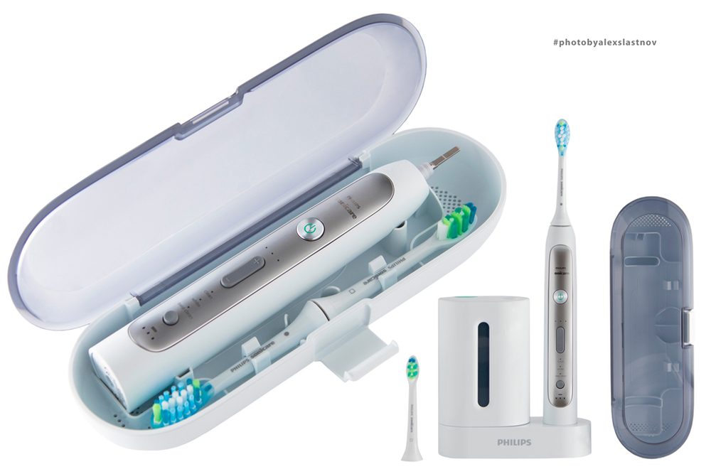 E-commerce packshot of an electric toothbrush with travel case, charger and brush heads on white