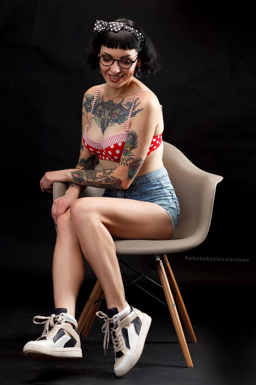 Model portfolio portrait of a woman seated on a modern polka-dot chair in a Boston studio