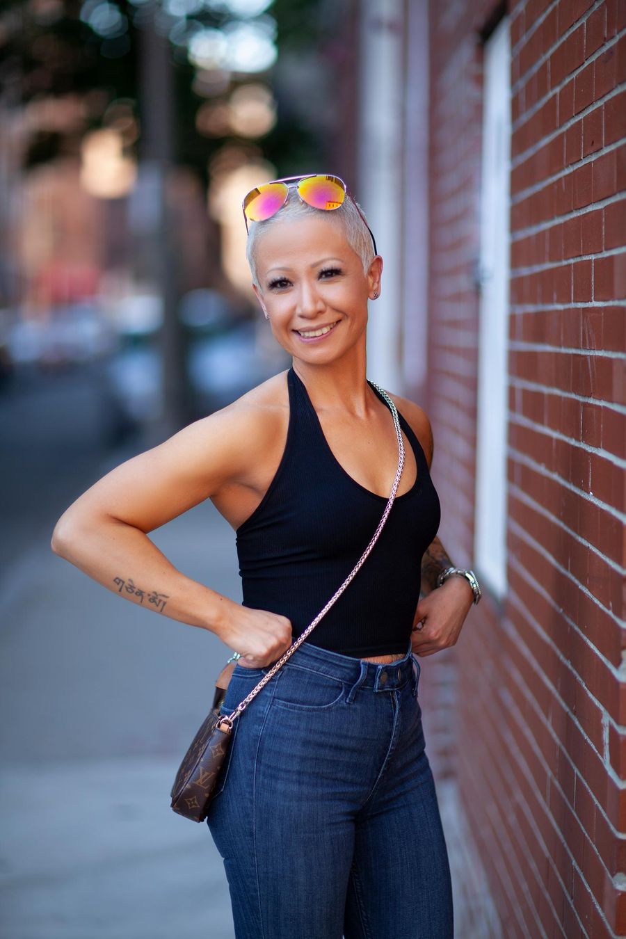 Outdoor portrait of a smiling woman against a red brick wall in Boston