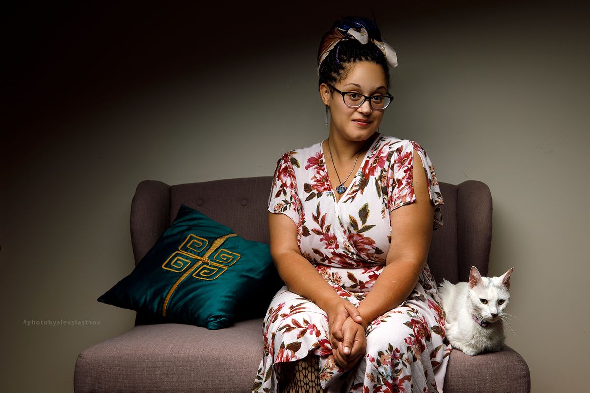 Portrait of a woman seated on a sofa with a white cat, Boston studio portrait