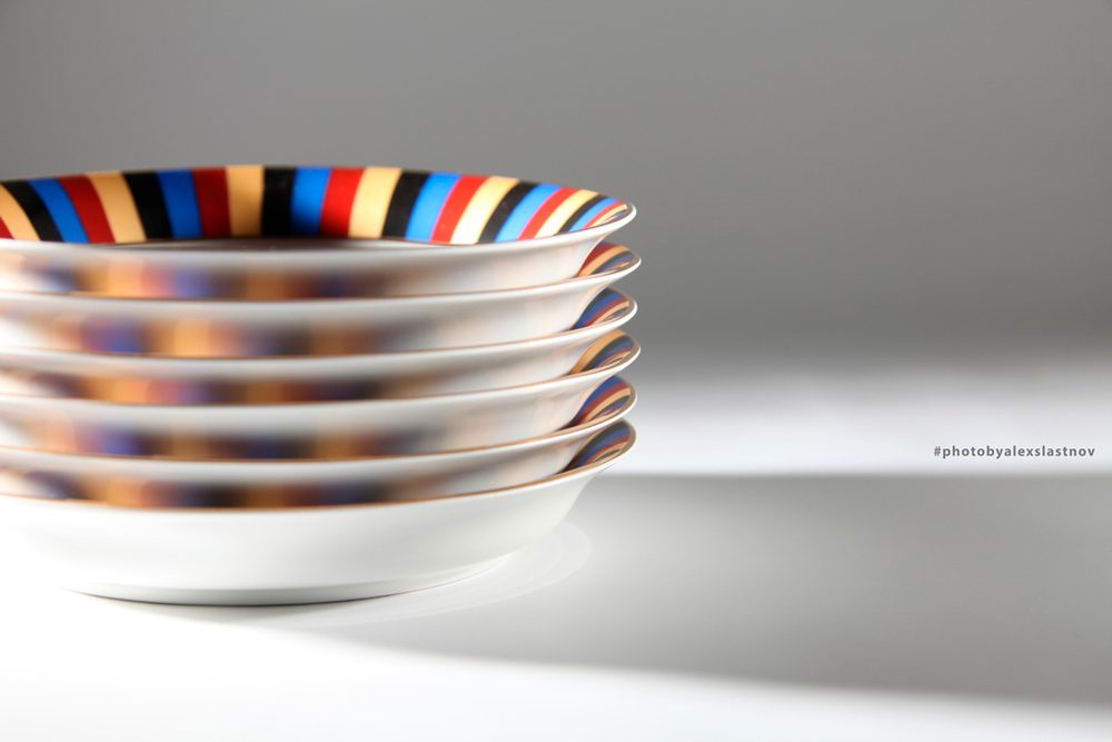 Stack of striped porcelain plates, studio product photo with soft light